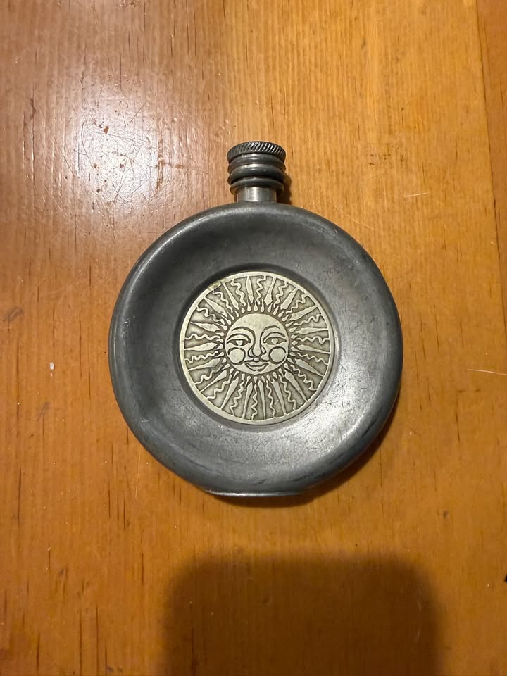 Pewter pocket flask with sun face medallion